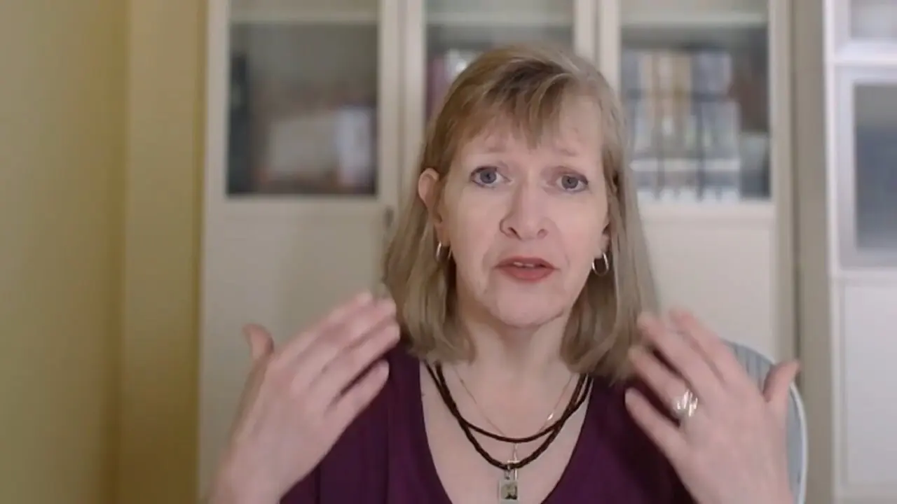 Woman speaking with expressive hand gestures at home.